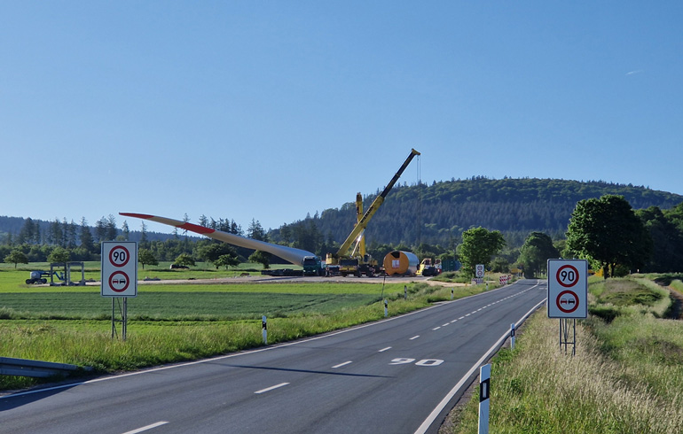 Ein Rotorblatt wird am Umladeplatz Oberems auf den Selbstfahrer montiert.